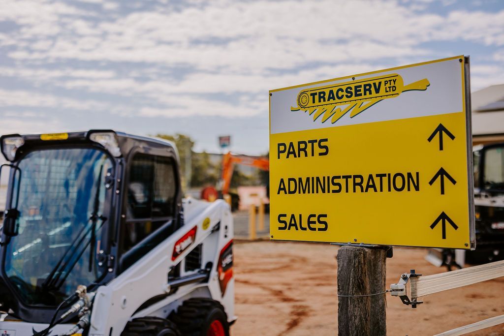 A Bulldozer Is Parked In Front Of A Yellow Sign That Says Parts Administration Sales — Tracserv in Dubbo, NSW