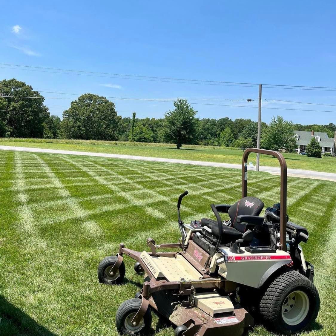 A Lawn Mower Is Sitting In The Middle Of A Lush Green Field — Tracserv in Dubbo, NSW