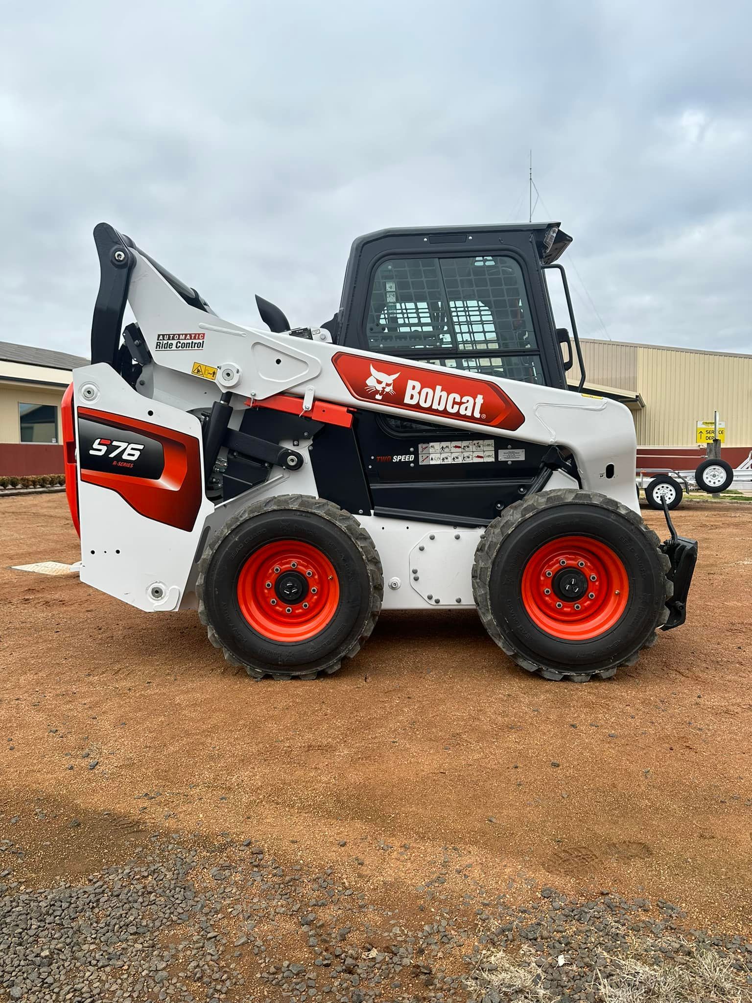 A Bobcat Skid Steer Loader Is Parked In A Gravel Lot — Tracserv in Bourke, NSW