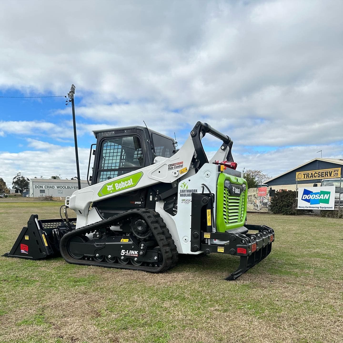 A Bulldozer Is Parked In A Grassy Field — Tracserv in Parkes, NSW