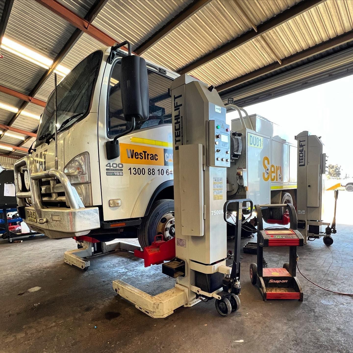 A Truck Is Sitting On A Lift In A Garage — Tracserv in Parkes, NSW