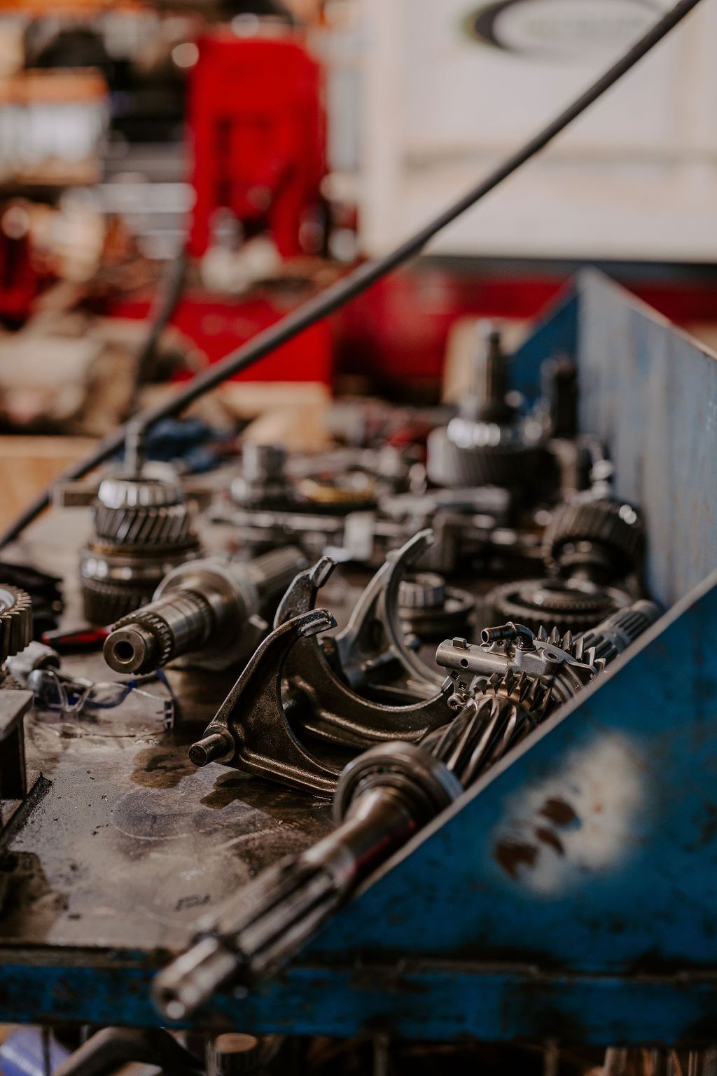 A Bunch Of Metal Parts Are Sitting On A Table In A Garage — Tracserv in Dubbo, NSW