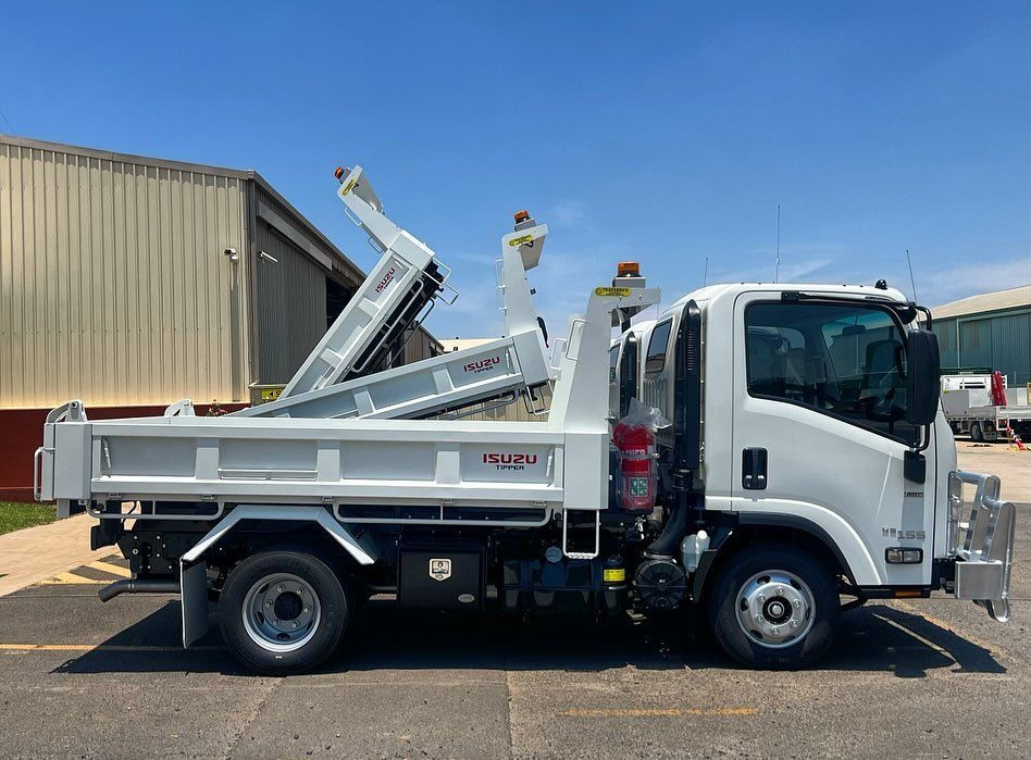 A White Dump Truck Is Parked In Front Of A Building — Tracserv in Bourke, NSW