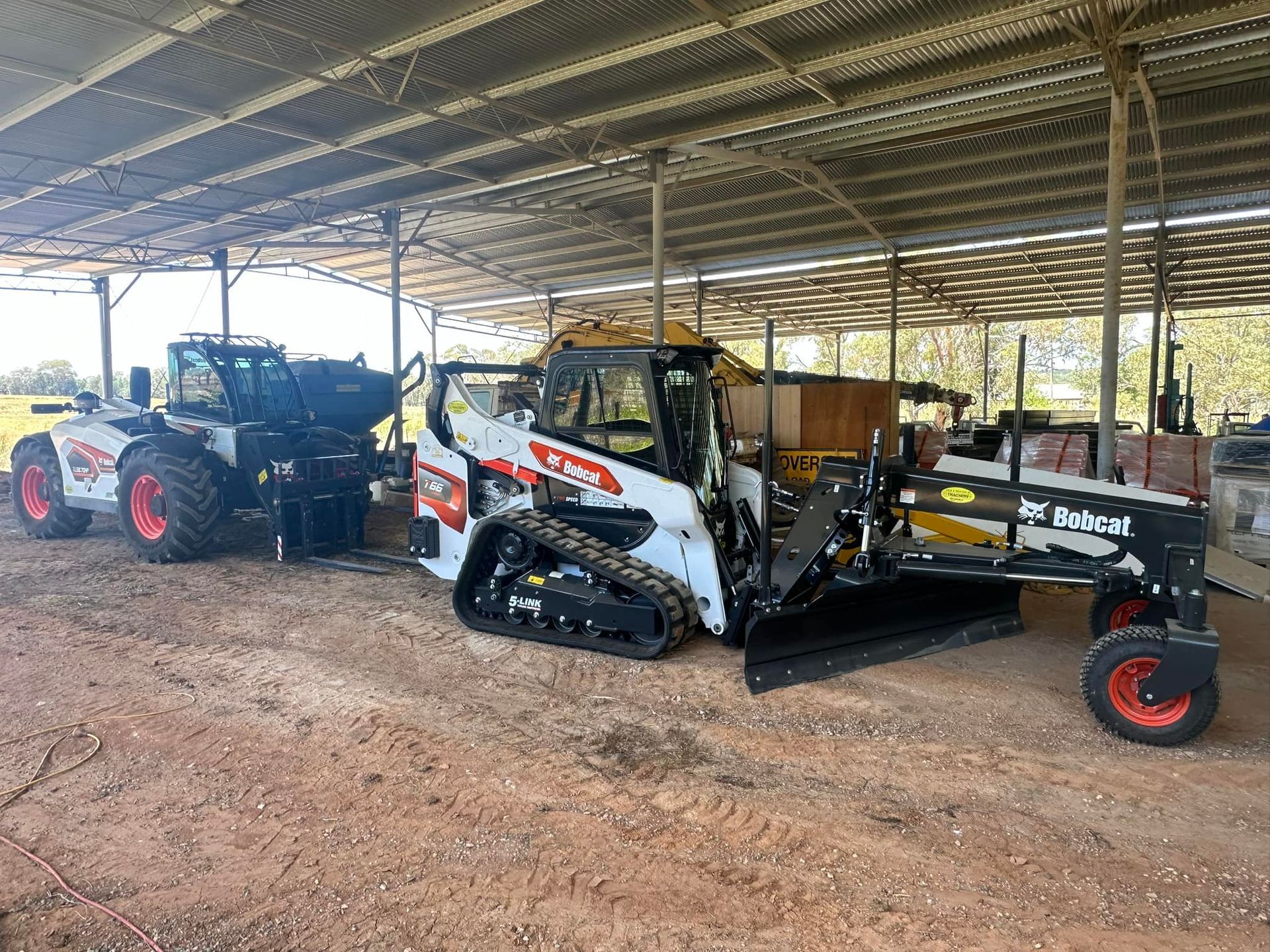 A Couple Of Tractors Are Parked Under A Covered Area — Tracserv in Bourke, NSW