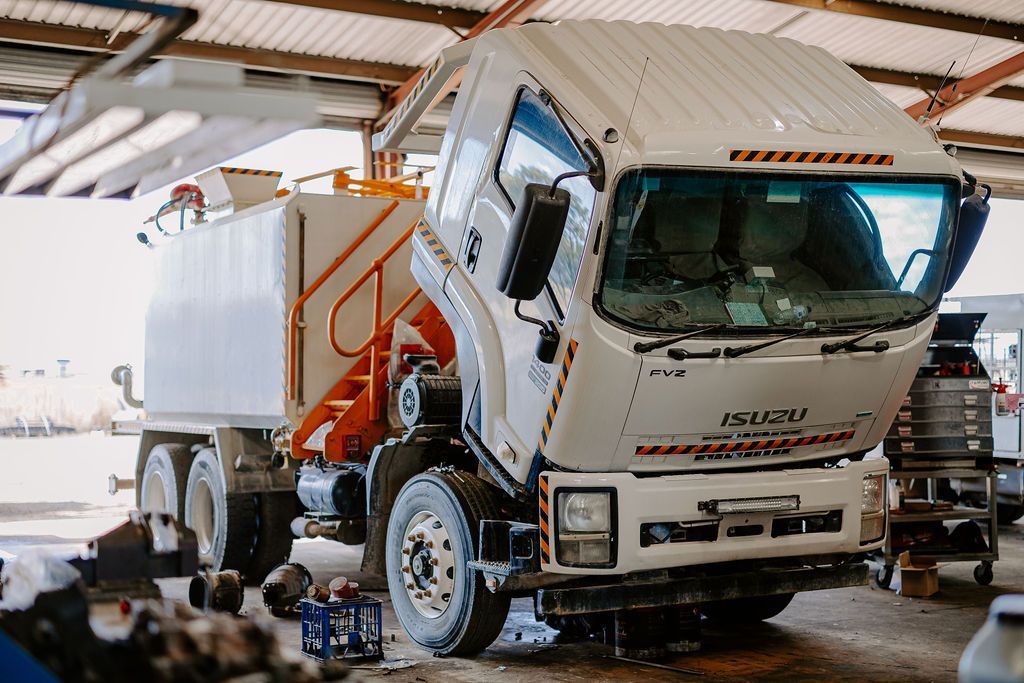 A Truck Is Parked In A Gravel Lot In Front Of A Building — Tracserv in Mudgee, NSW