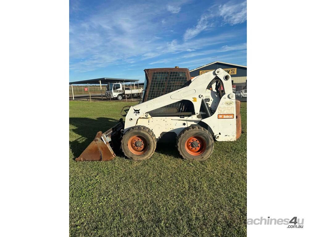 White Skid Steer With Bucket on Grassy Field — Tracserv in Dubbo, NSW