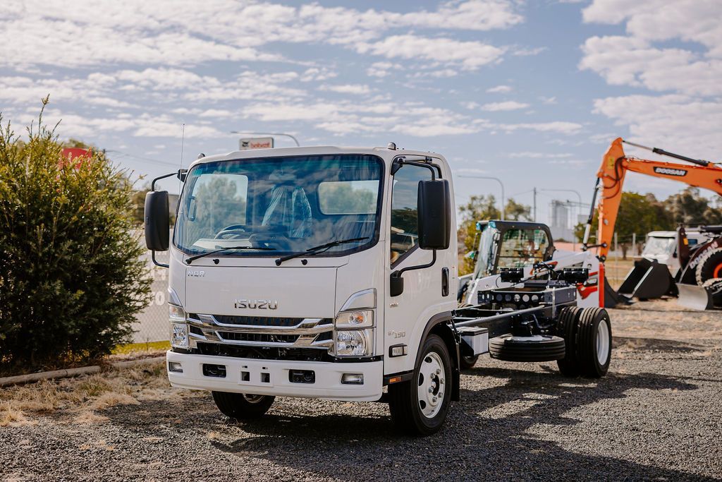 A White Truck Is Parked In A Gravel Lot Next To An Excavator — Tracserv in Mudgee, NSW