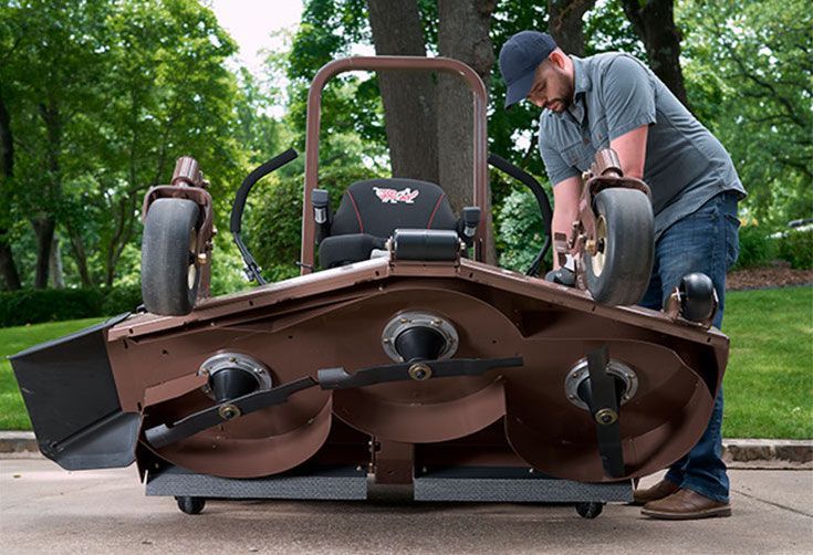 A Man Is Working On A Lawn Mower On The Side Of The Road — Tracserv in Dubbo, NSW