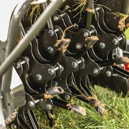 Close-Up of A Lawn Aerator, with Rotating Tines Removing Soil Plugs from Grass — Tracserv in Dubbo, NSW