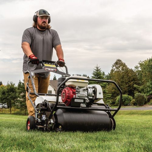 Man Operating a Lawn Aerator on a Green Lawn — Tracserv in Dubbo, NSW