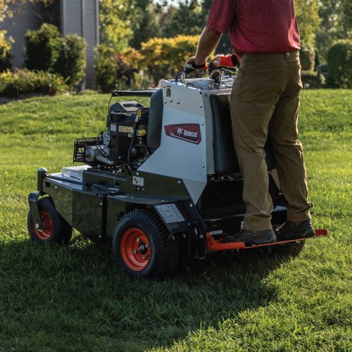 Person Operating a Bobcat Aerator on A Grassy Lawn — Tracserv in Dubbo, NSW