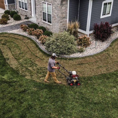 Person Mowing a Front Yard with A Lawnmower in Front of A House — Tracserv in Dubbo, NSW