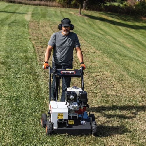 Person Using a Bobcat Sod Cutter on A Grassy Slope, Wearing Ear Protection — Tracserv in Dubbo, NSW