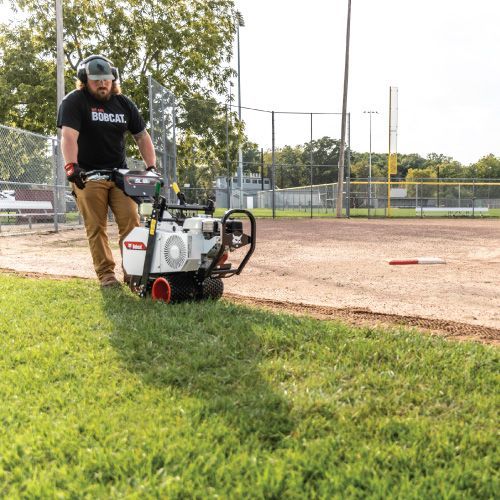 A Person Operating a Field Edger, Trimming Grass Along a Baseball Infield — Tracserv in Dubbo, NSW