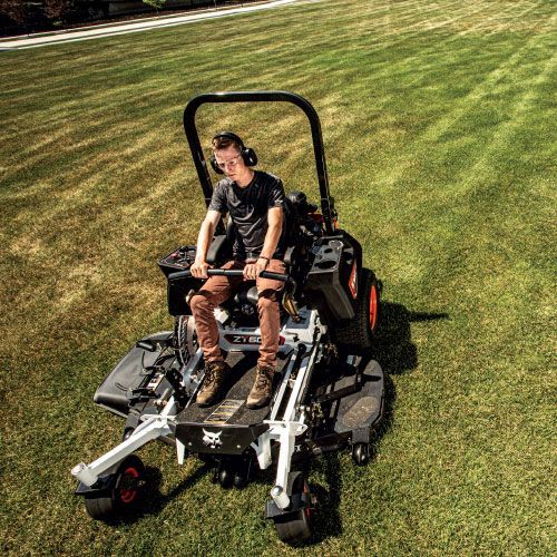 Person Operating a Bobcat Zero-Turn Mower on A Grassy Lawn, Wearing Ear Protection — Tracserv in Dubbo, NSW