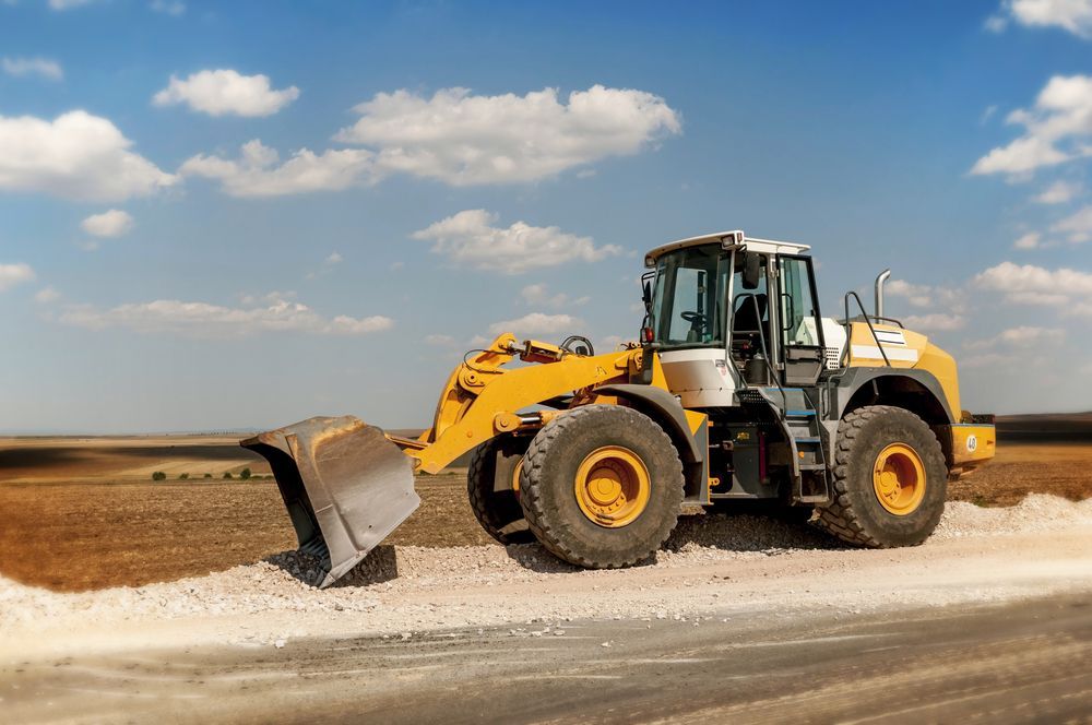 A Yellow Bulldozer Is Sitting On The Side Of A Road — Tracserv in Bathurst, NSW