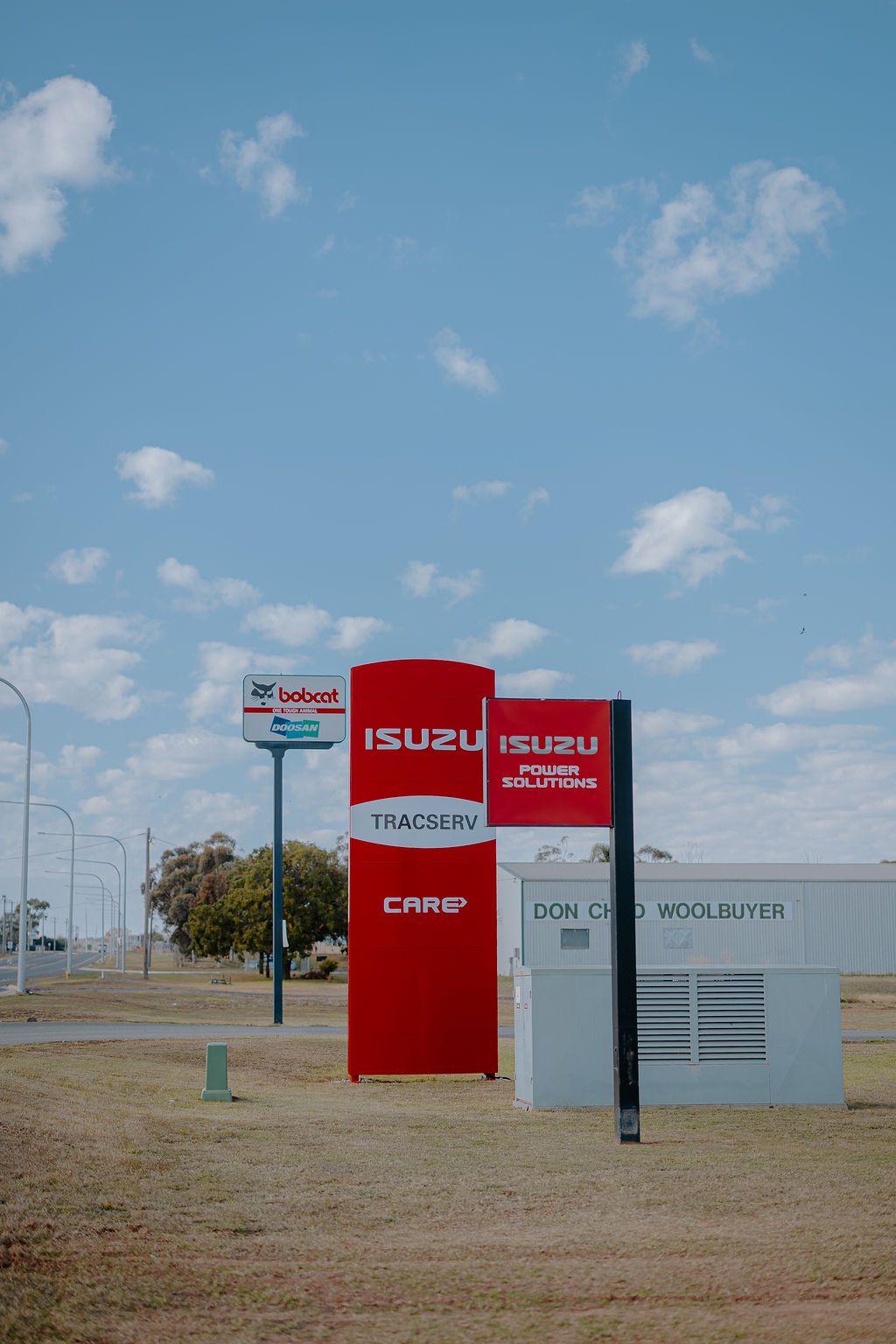 A Red And White Isuzu Sign Is In The Middle Of A Field — Tracserv in Dubbo, NSW