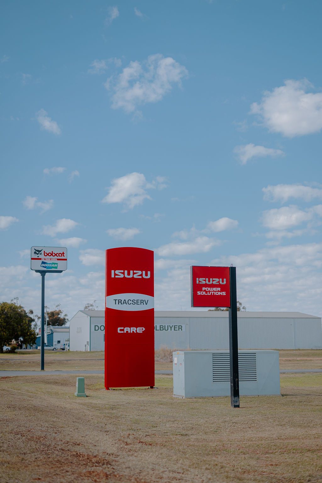 A Red Isuzu Sign Is In The Middle Of A Field — Tracserv in Dubbo, NSW