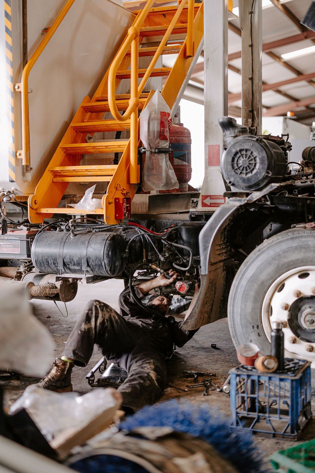 A Man Is Working On A Truck In A Garage — Tracserv in Dubbo, NSW