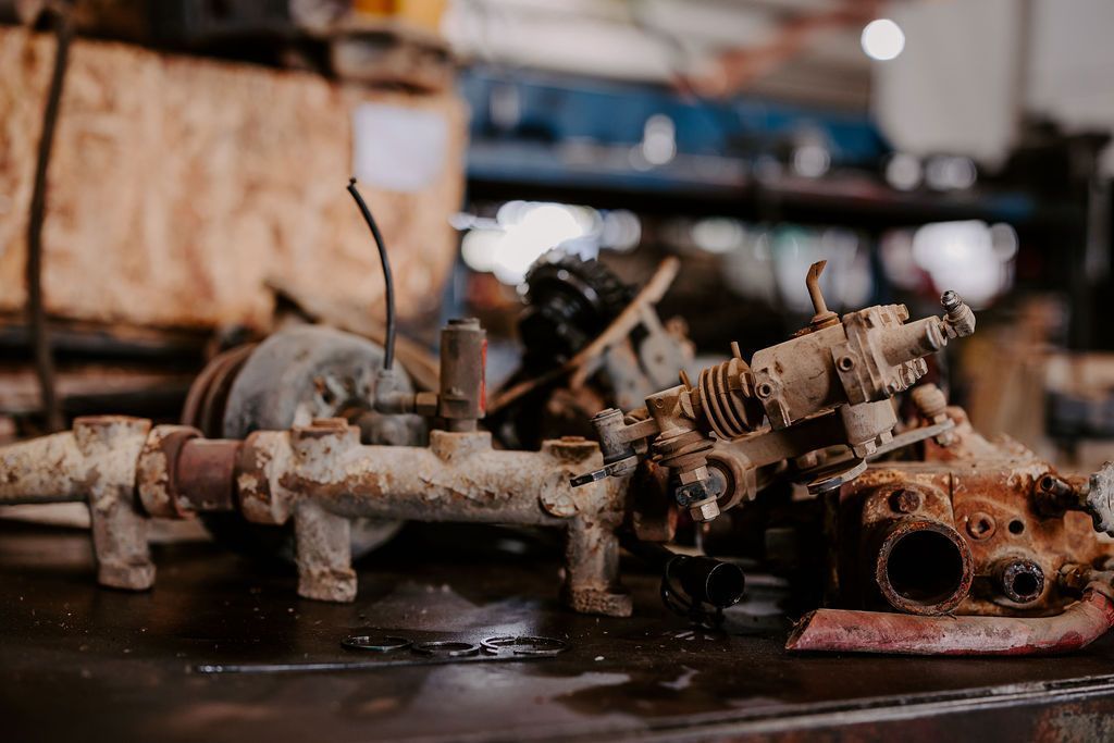 A Bunch Of Rusty Parts Are Sitting On A Table In A Garage — Tracserv in Orange, NSW