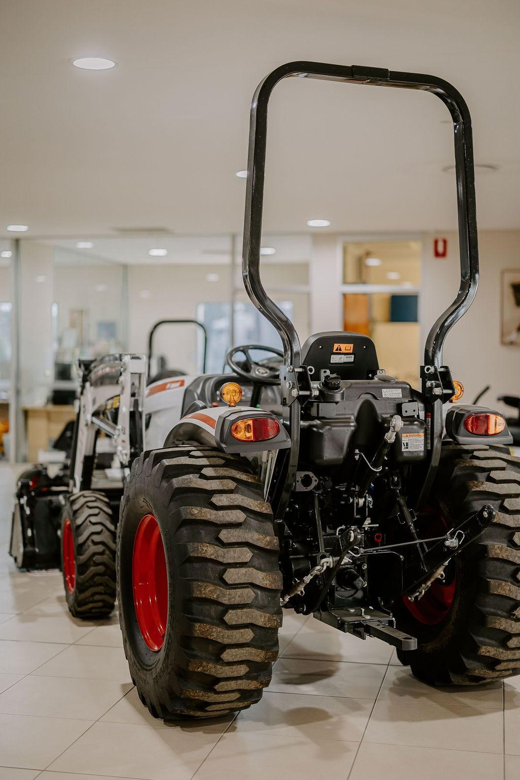 A Tractor Is Parked In A Showroom Next To A Bulldozer — Tracserv in Bourke, NSW