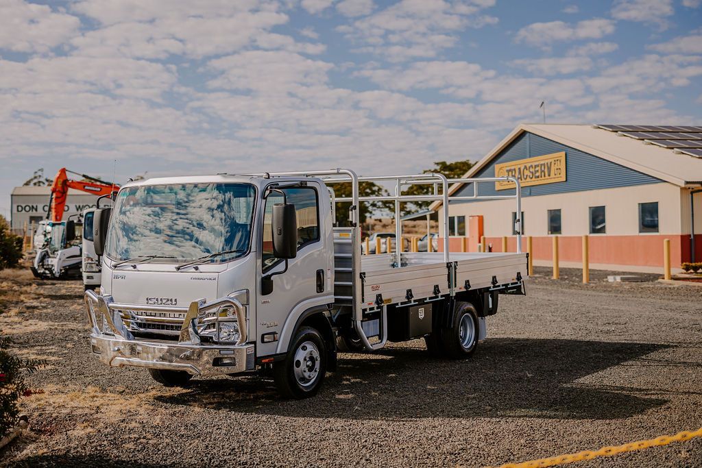 A White Truck Is Parked In A Gravel Lot In Front Of A Building — Tracserv in Dubbo, NSW