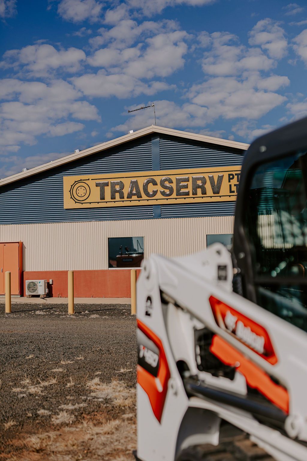 A Bulldozer Is Parked In Front Of A Building — Tracserv in Orange, NSW