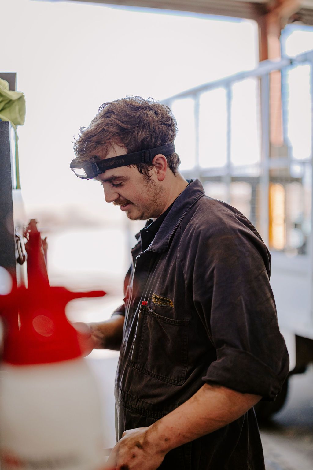 A Man Wearing A Headband Is Working On A Machine In A Garage — Tracserv in Dubbo, NSW