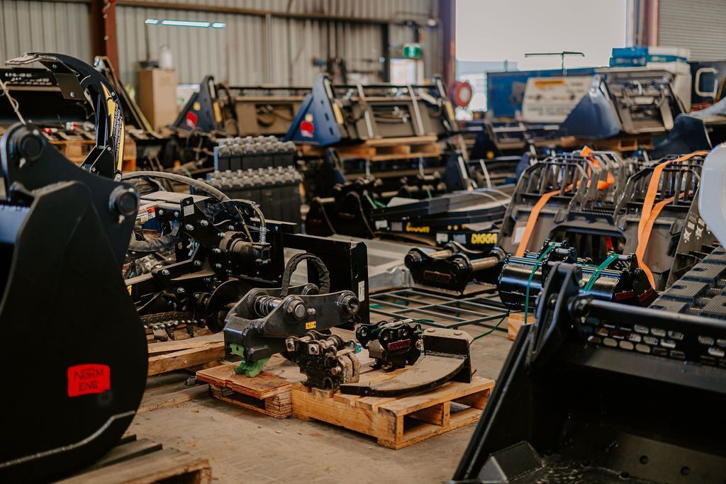 Workshop interior with disassembled heavy machinery parts on pallets.