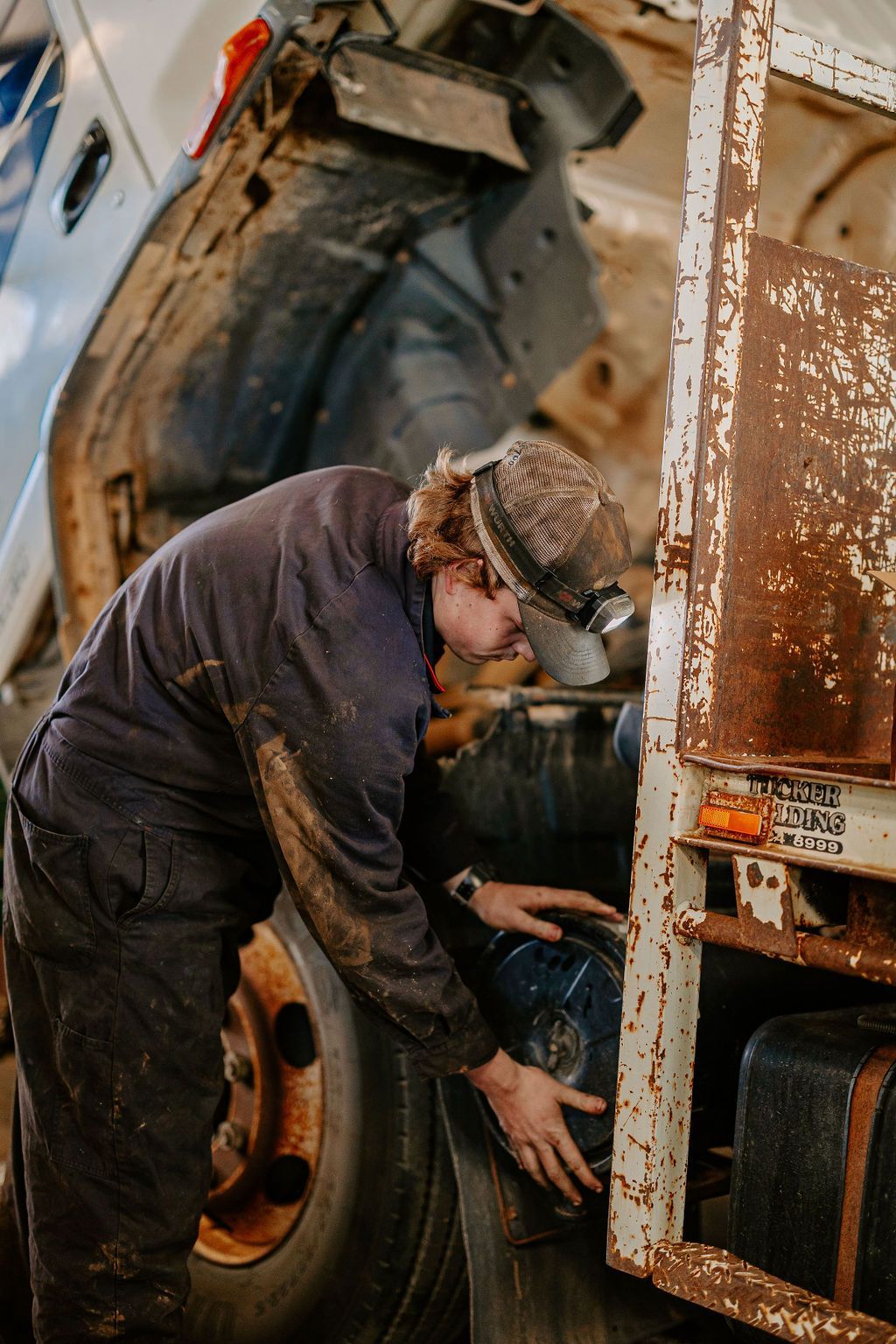 A Man Is Working On A Truck In A Garage — Tracserv in Dubbo, NSW