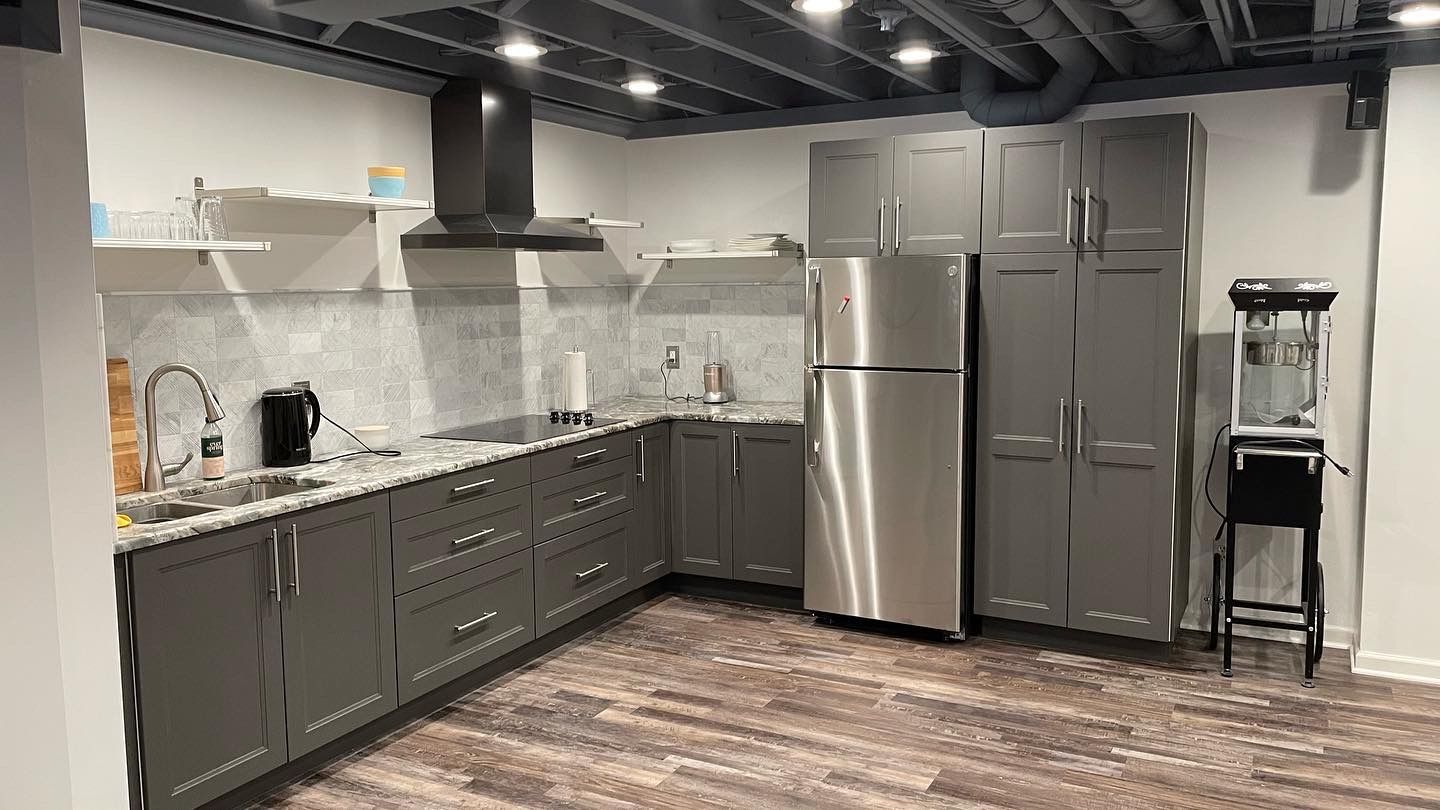 a kitchen with stainless steel appliances and gray cabinets .