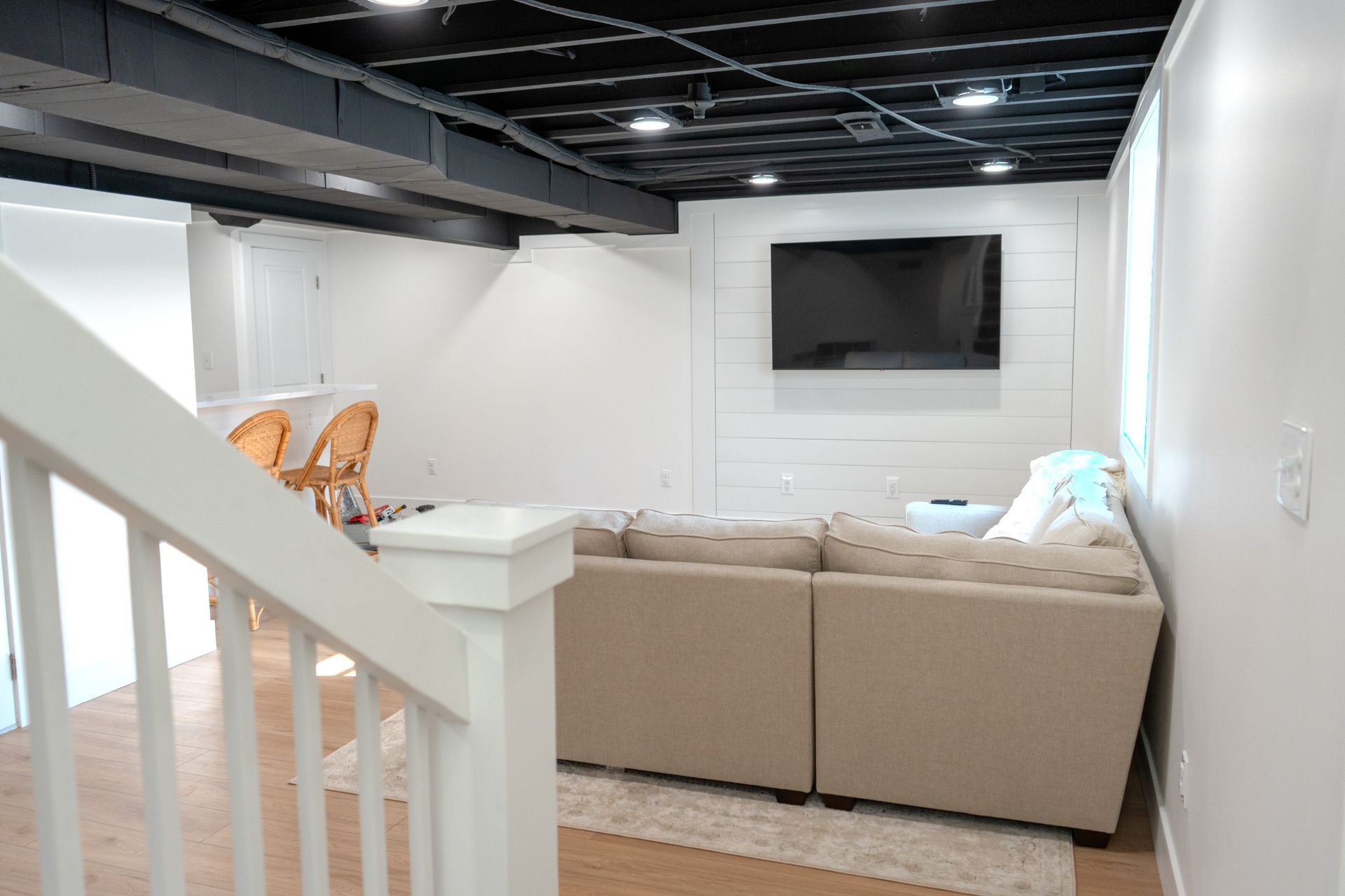 A living room with a couch and a flat screen tv on the wall.