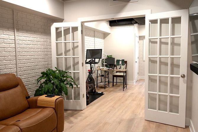 A living room with a couch , chair , desk and a bicycle.