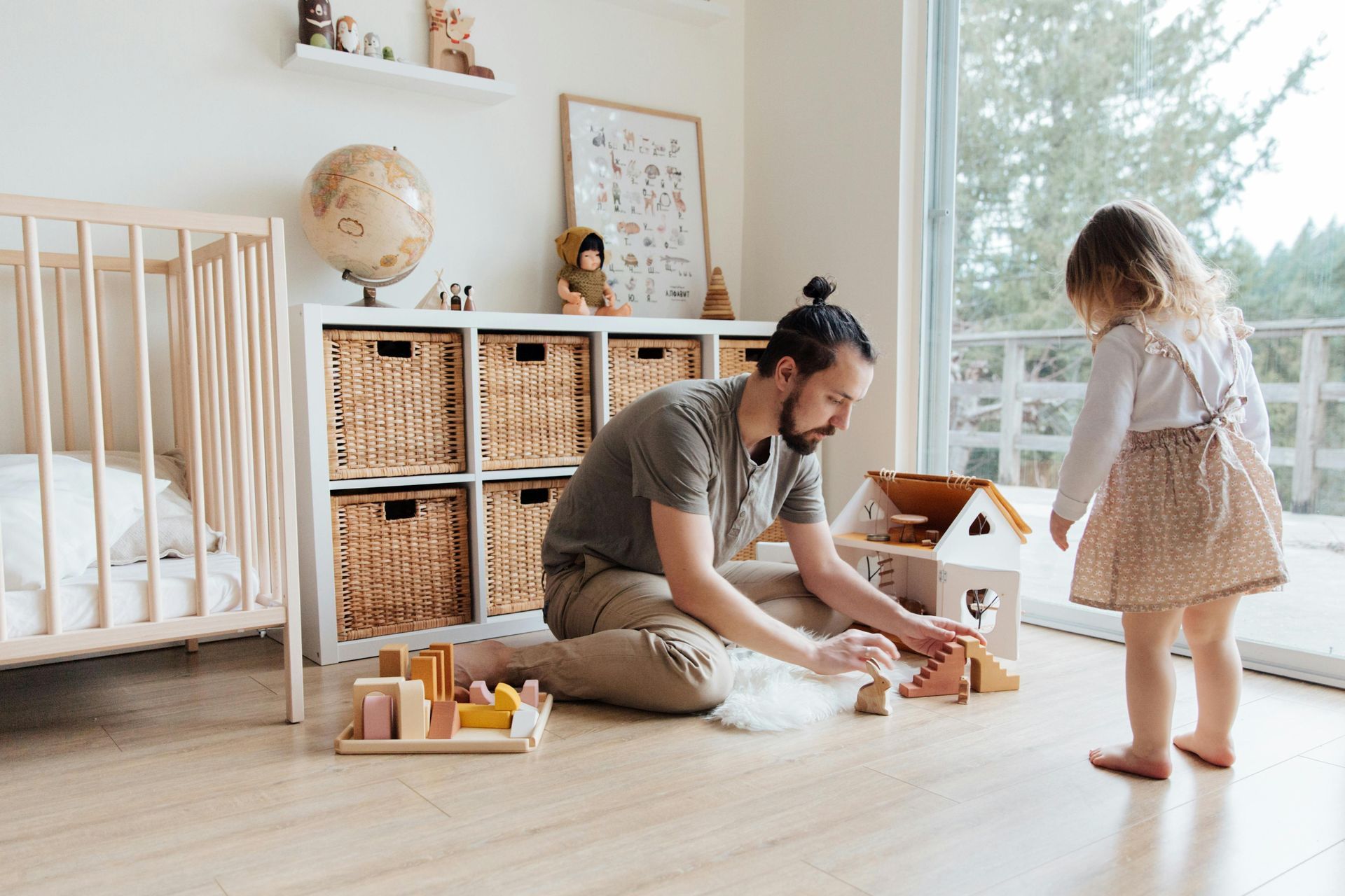 A man and a little girl are playing with toys in a room.