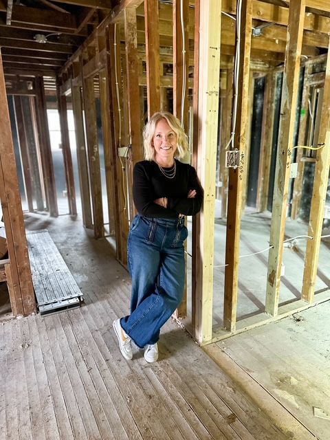 A woman is standing in a building under construction.