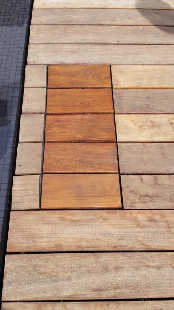 Wooden deck with a rectangular section of darker wood.
