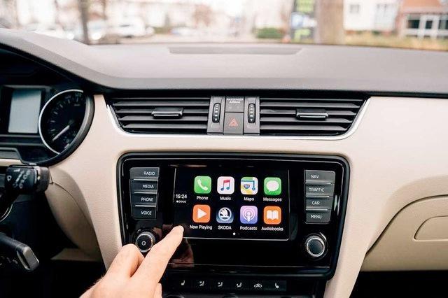 A person is pressing a button on a car radio.