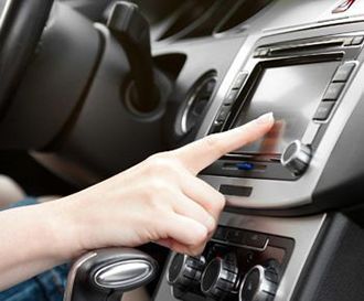 A person is pressing a button on a car radio