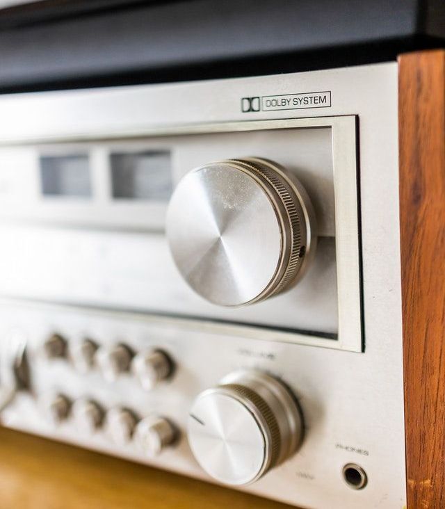 a close up of a stereo amplifier on a wooden shelf .