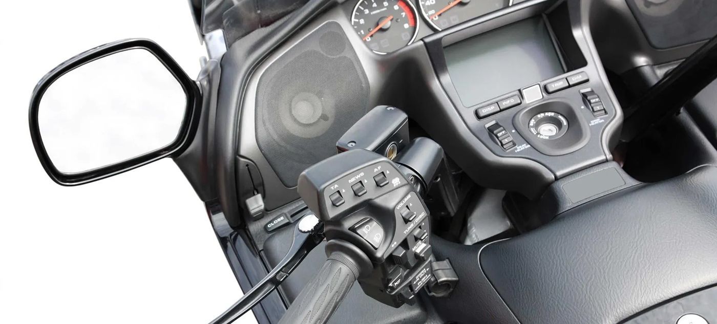 A close up of a motorcycle dashboard with a rear view mirror.
