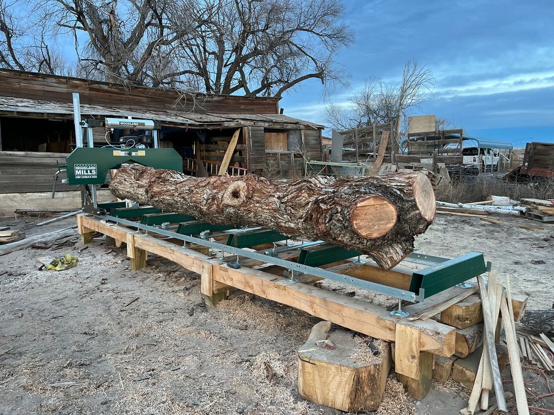 A large log on a sawmill in an outdoor setting.