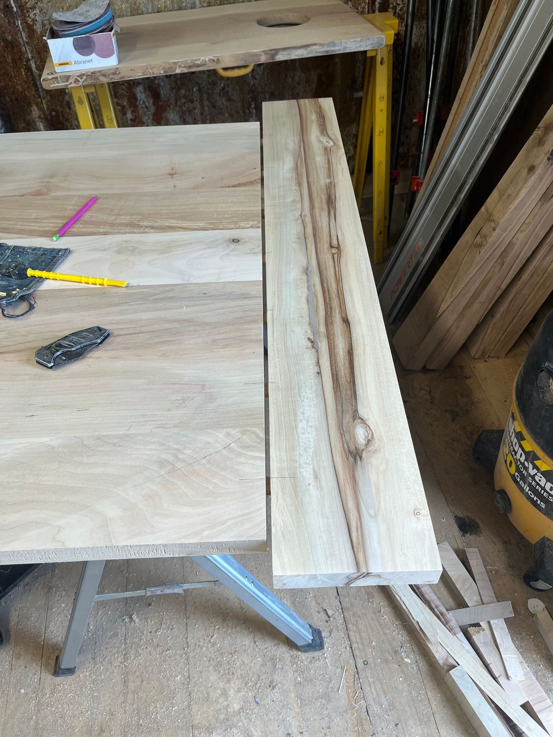Woodworker with a wooden board on a workbench, ready for cutting and assembly.