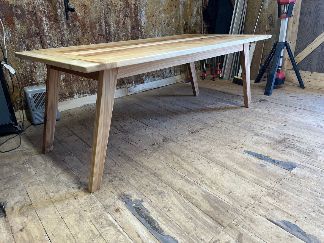 Wooden dining table in a workshop setting.