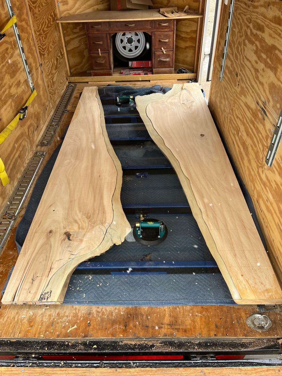 Two live edge wood slabs inside a wooden truck.