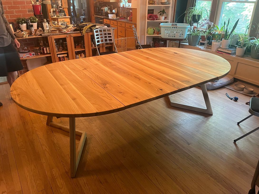 Oval wooden dining table in a home setting.
