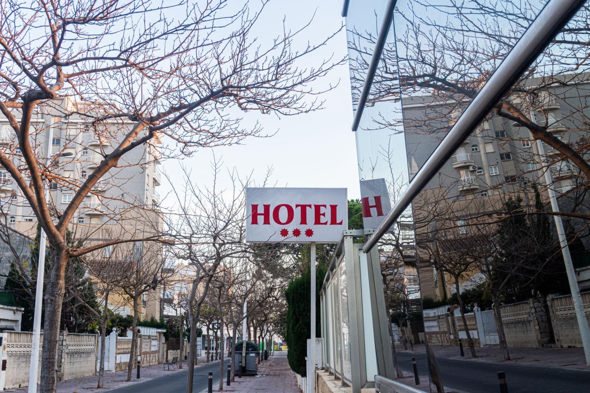 Foto do letreiro de um hotel urbano acompanhado do fechamento de um restaurante anexo