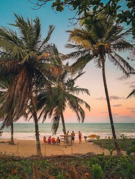 Família chegando a pousada à beira-mar no Nordeste brasileiro simbolizando as férias de julho
