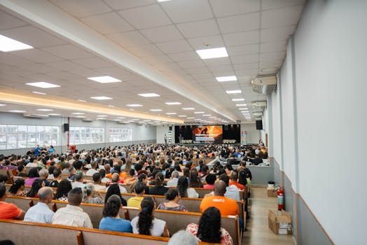 Plateia de profissionais em congresso de hotelaria acompanhando palestra sobre tendências do setor