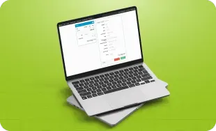 Laptop prateado exibindo uma planilha sobre um fundo verde brilhante.