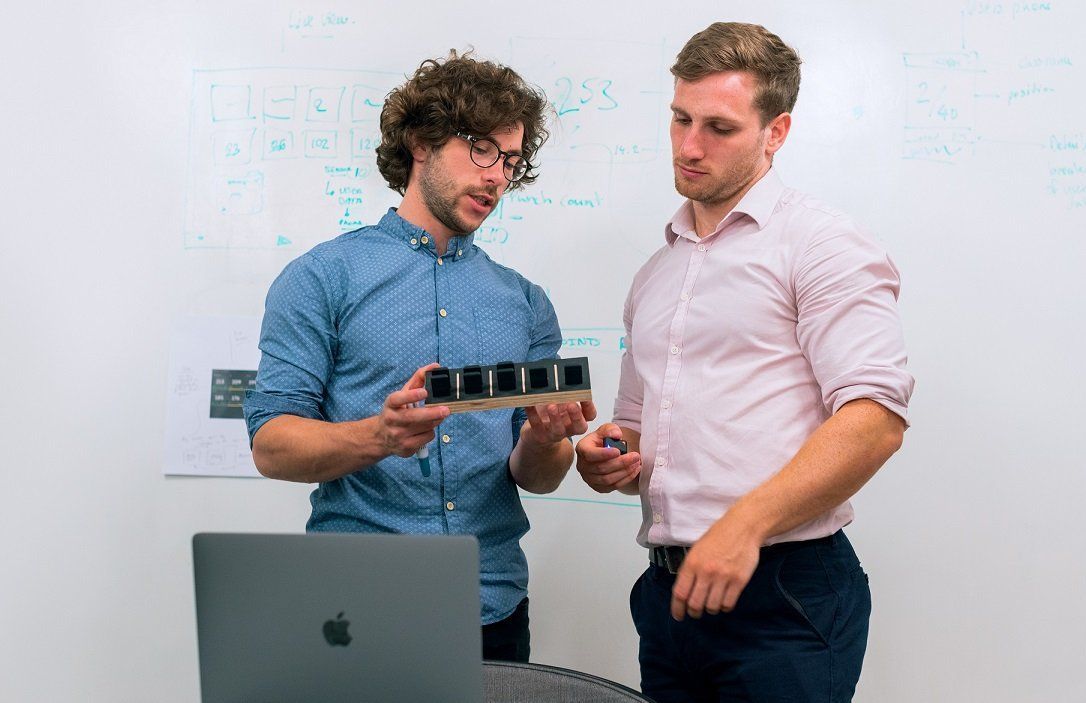 two electronics design engineers inspecting at prototype